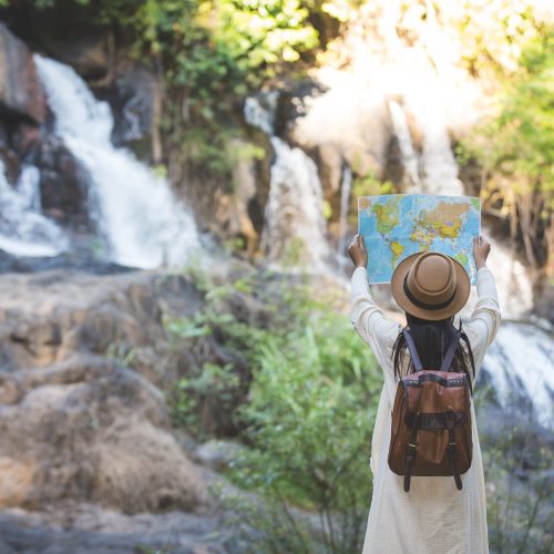 Female tourists on hand have a happy travel map.